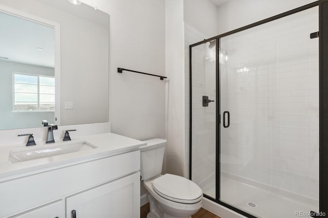 bathroom featuring vanity, toilet, and walk in shower