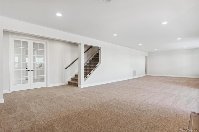 basement featuring light colored carpet and french doors