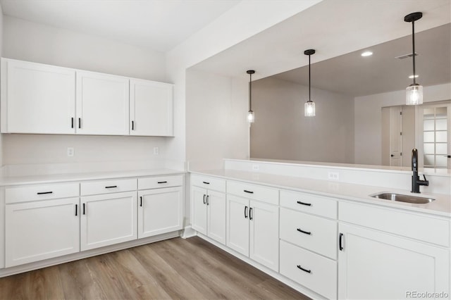 kitchen featuring kitchen peninsula, sink, and hanging light fixtures