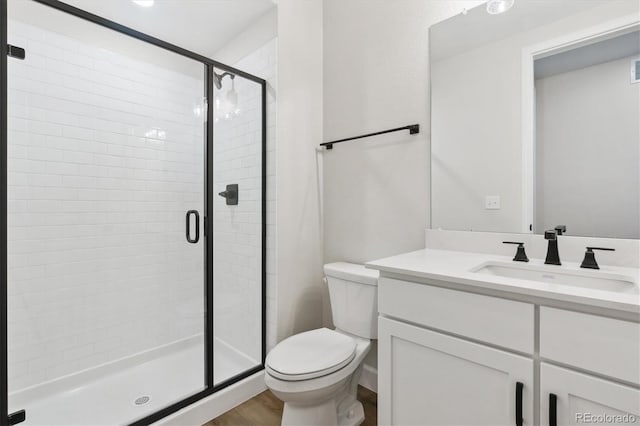 bathroom featuring hardwood / wood-style flooring, vanity, an enclosed shower, and toilet