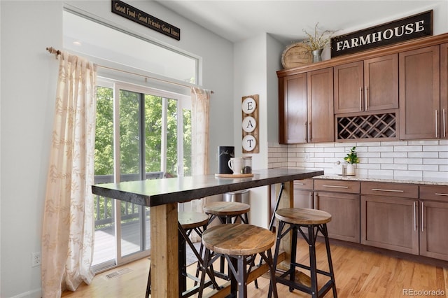 15502 E Flower Mound Pl, Parker, CO 80134 - kitchen featuring backsplash, light wood-style floors, and light stone counters