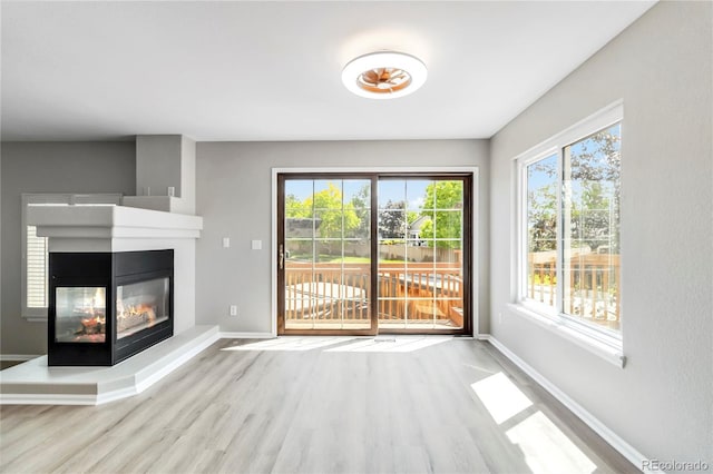1526 Braewood Ave, Littleton, CO 80129 - unfurnished living room featuring wood finished floors, healthy amount of natural light, and baseboards