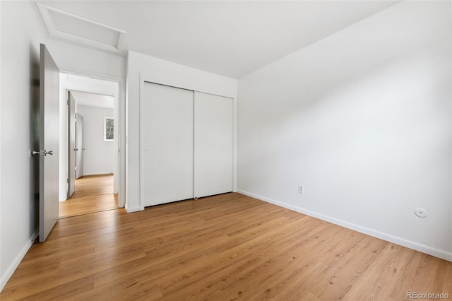 4617 S Norfolk Way, Aurora, CO 80015 - unfurnished bedroom with attic access, light wood-style flooring, and a closet