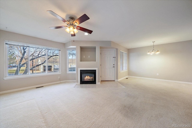 unfurnished living room featuring light carpet and ceiling fan with notable chandelier