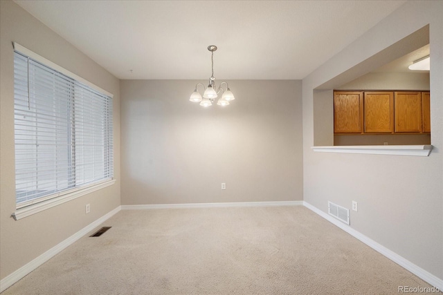 unfurnished room with light colored carpet and an inviting chandelier