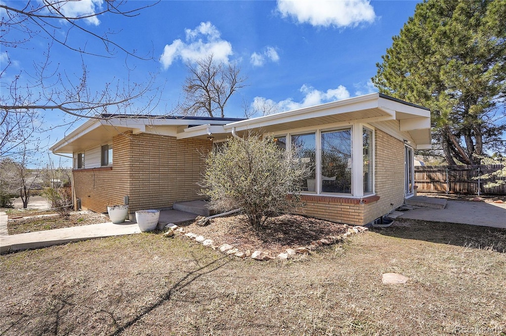 8005 Emerald Ln, Broomfield, CO 80020 - view of side of property with fence and brick siding