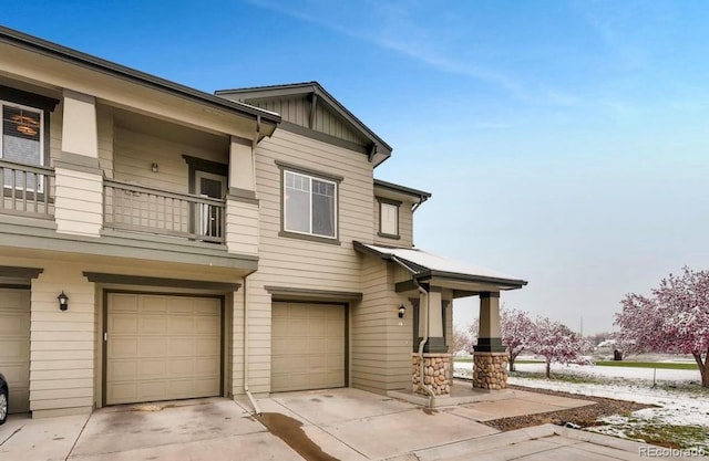 12914 Grant Cir Unit C, Thornton, CO 80241 - view of front facade featuring a garage, driveway, a balcony, board and batten siding, and covered porch