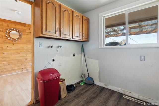 washroom featuring wooden walls, cabinets, dark wood-type flooring, and hookup for a washing machine