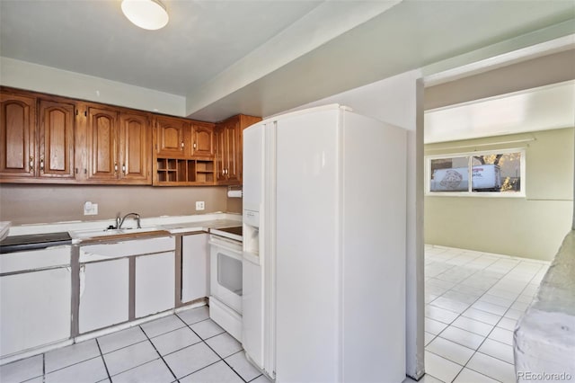 kitchen featuring white appliances, sink, and light tile patterned floors