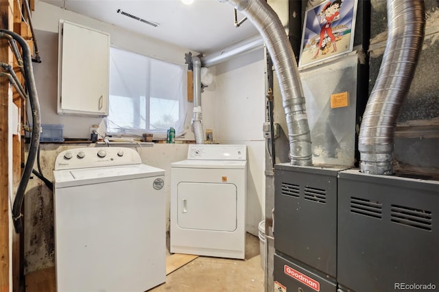 laundry room with heating unit and washing machine and clothes dryer