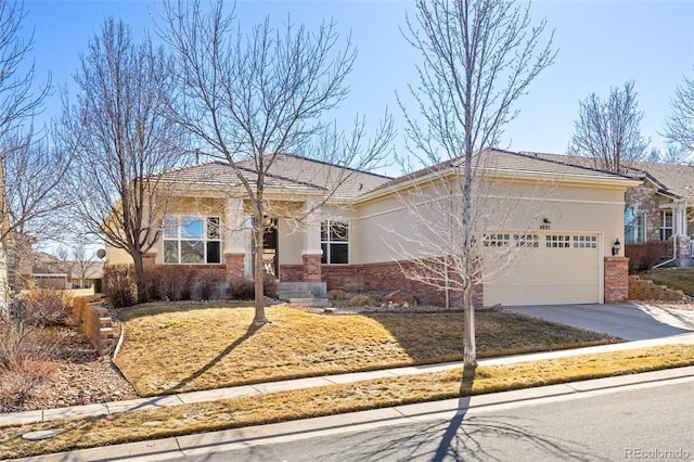 view of front of home featuring concrete driveway, brick siding, an attached garage, and stucco siding