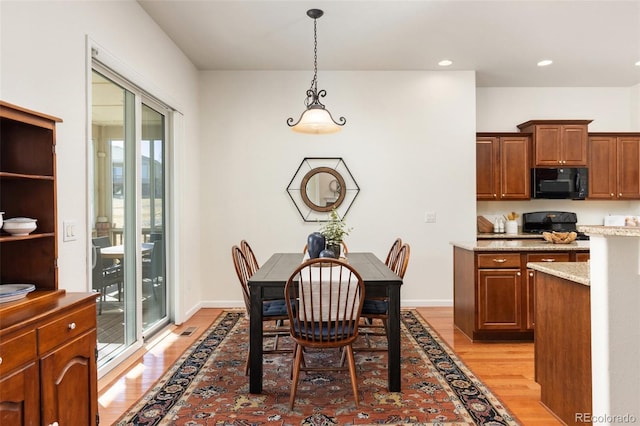 dining space with baseboards, light wood-type flooring, and recessed lighting