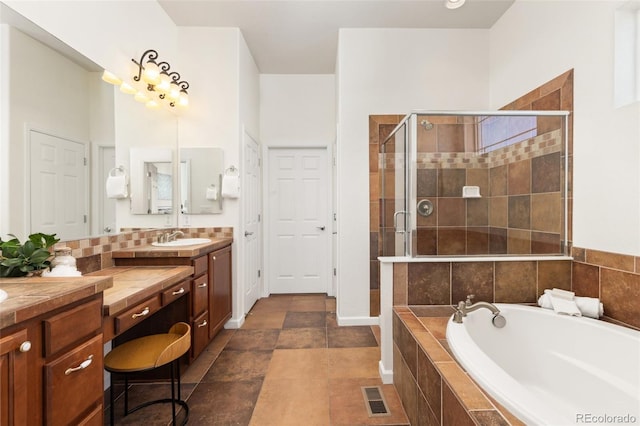 full bathroom featuring visible vents, decorative backsplash, a garden tub, vanity, and a shower stall