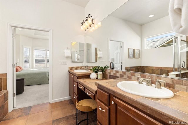 ensuite bathroom featuring baseboards, connected bathroom, vanity, and tile patterned floors