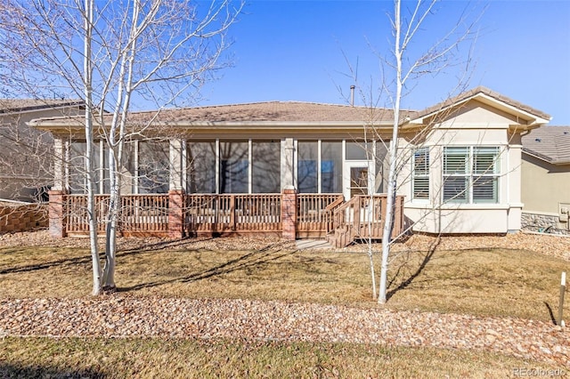 back of house with a sunroom and stucco siding