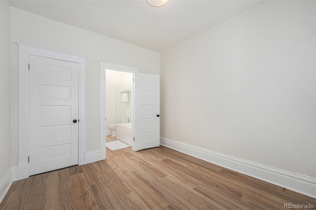 715 W 7th Ave, Denver, CO 80204 - unfurnished bedroom with light wood-style flooring and connected bathroom