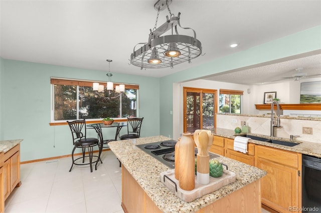 kitchen with sink, decorative light fixtures, black appliances, a kitchen island, and backsplash