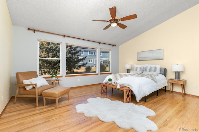 bedroom featuring ceiling fan, lofted ceiling, light hardwood / wood-style flooring, and a textured ceiling