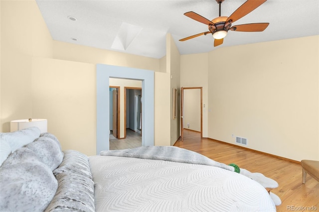 bedroom with vaulted ceiling, ceiling fan, and light wood-type flooring