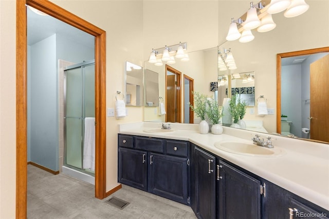 bathroom featuring a shower with door, vanity, and toilet