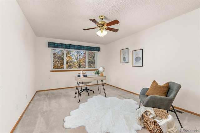 office space featuring ceiling fan, light colored carpet, and a textured ceiling