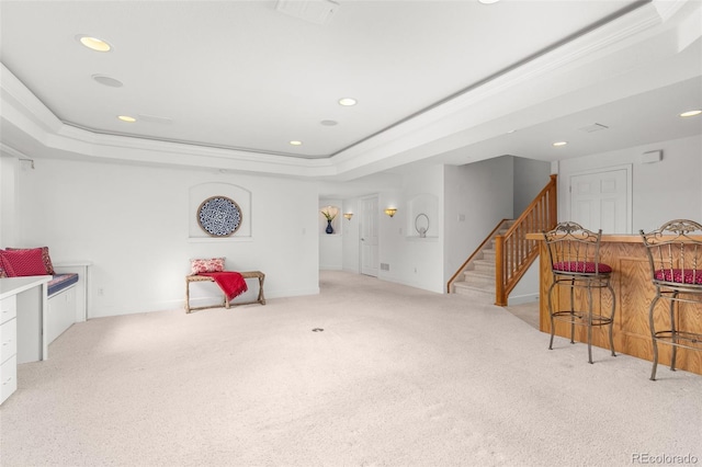 sitting room featuring a raised ceiling, ornamental molding, and light colored carpet