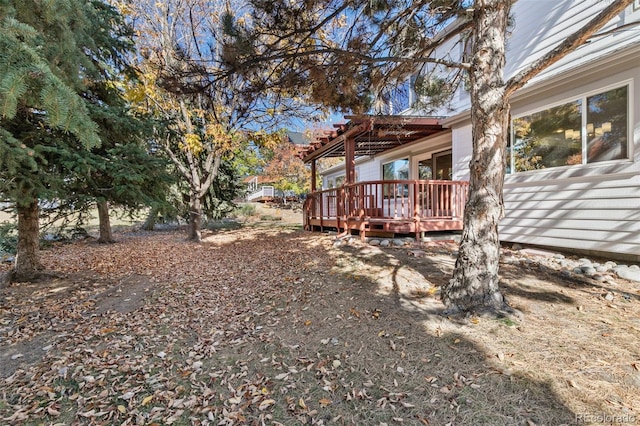 view of yard with a wooden deck and a pergola