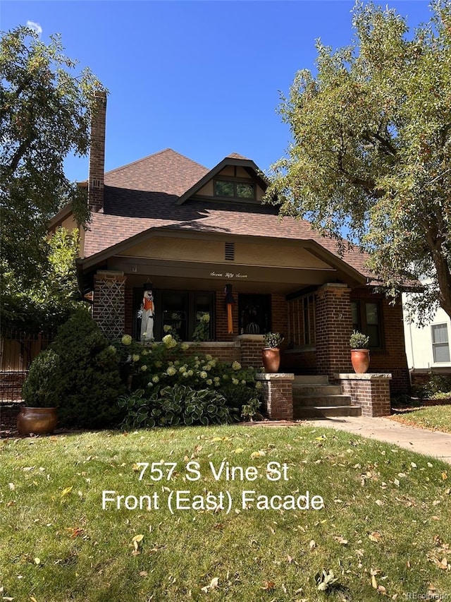 view of front of property featuring covered porch and a front yard