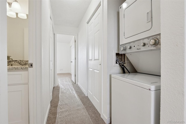 washroom featuring light colored carpet and stacked washer and dryer