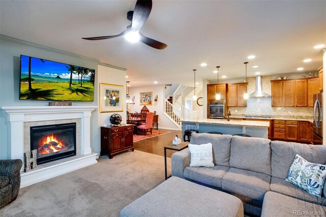 2415 Bluestem Willow Dr, Loveland, CO 80538 - living room with stairway, a ceiling fan, recessed lighting, a fireplace, and light colored carpet