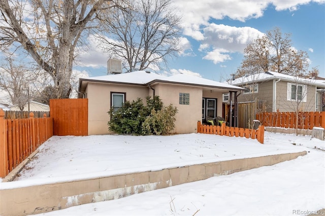 view of front facade featuring fence and stucco siding