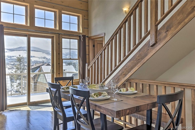 dining room with stairs, a high ceiling, a mountain view, and wood-type flooring