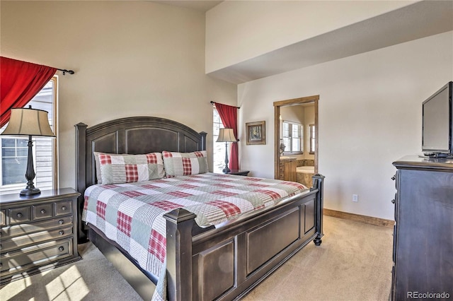 bedroom with light colored carpet, connected bathroom, and baseboards