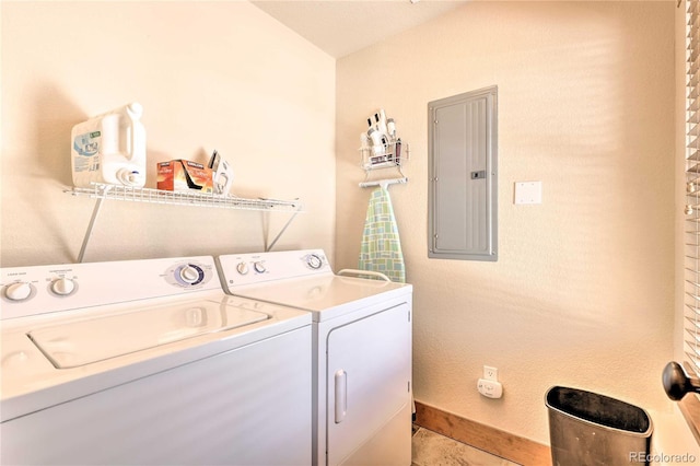 washroom featuring electric panel, laundry area, washing machine and dryer, and baseboards