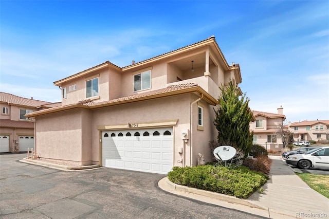7046 Sand Crest Vw, Colorado Springs, CO 80923 - view of front of home with stucco siding, an attached garage, a tile roof, and a residential view