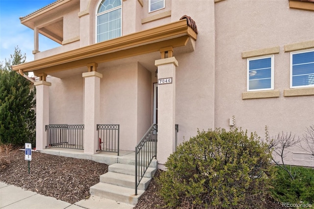 7046 Sand Crest Vw, Colorado Springs, CO 80923 - doorway to property featuring covered porch and stucco siding