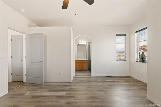 7046 Sand Crest Vw, Colorado Springs, CO 80923 - unfurnished bedroom featuring light wood finished floors, arched walkways, and baseboards
