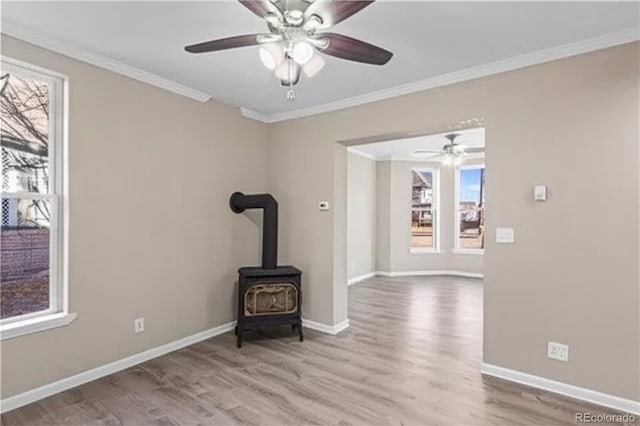 1021 Lake Ave, Pueblo, CO 81004 - unfurnished living room featuring wood finished floors, crown molding, ceiling fan, baseboards, and a wood stove