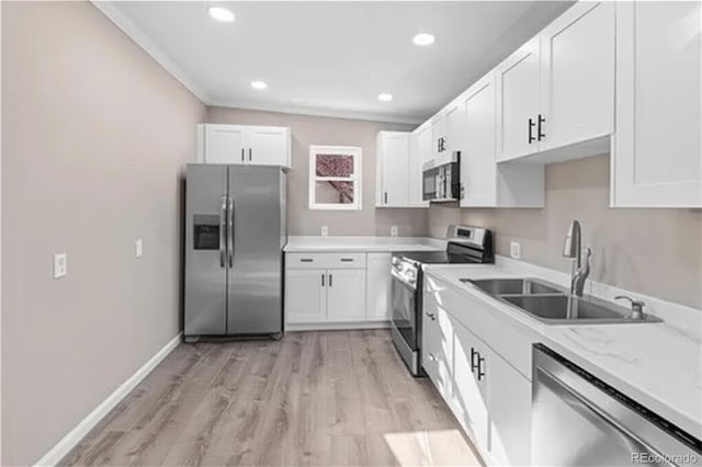 1021 Lake Ave, Pueblo, CO 81004 - kitchen with stainless steel appliances, a sink, white cabinets, light wood-type flooring, and recessed lighting
