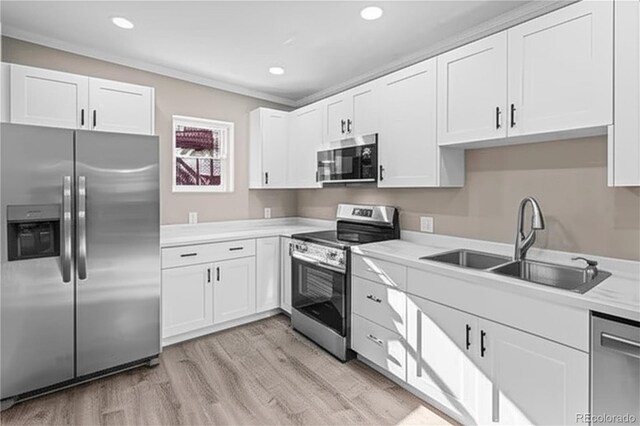 1021 Lake Ave, Pueblo, CO 81004 - kitchen with appliances with stainless steel finishes, a sink, light wood-style flooring, white cabinets, and light countertops