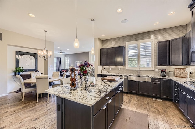 3477 New Haven Cir, Castle Rock, CO 80109 - kitchen featuring a sink, light wood-style floors, decorative backsplash, a center island, and recessed lighting