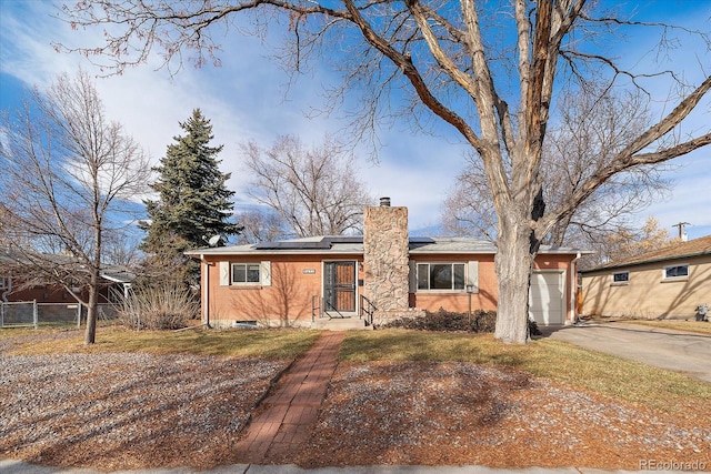 single story home with solar panels and a garage