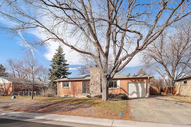 ranch-style house featuring solar panels and a garage