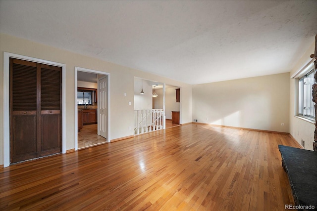 unfurnished living room featuring hardwood / wood-style flooring and sink