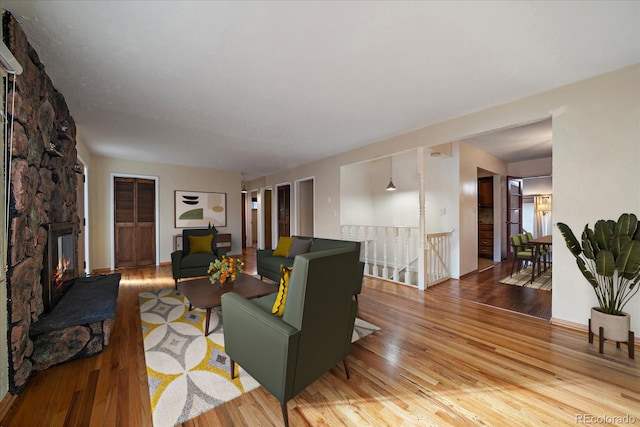 living room featuring light wood-type flooring and a fireplace