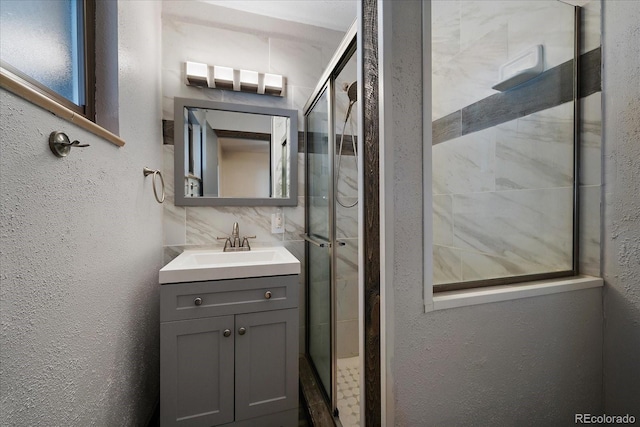 bathroom featuring backsplash, vanity, and walk in shower