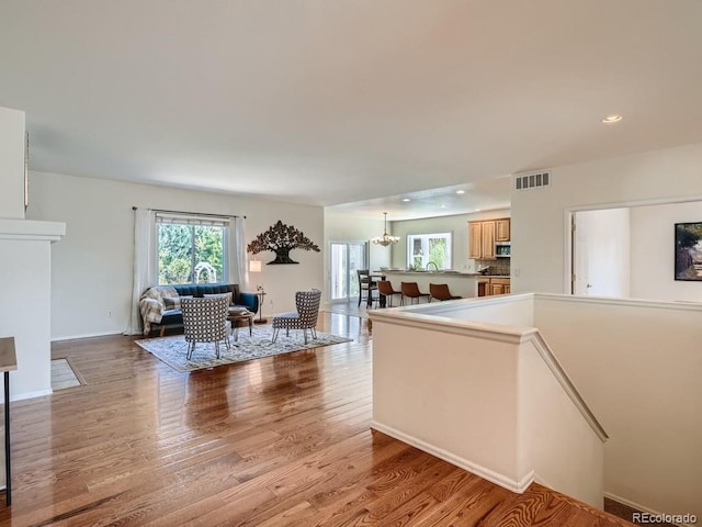 7746 S Valdai Ct, Aurora, CO 80016 - living area with light wood finished floors, a chandelier, and recessed lighting