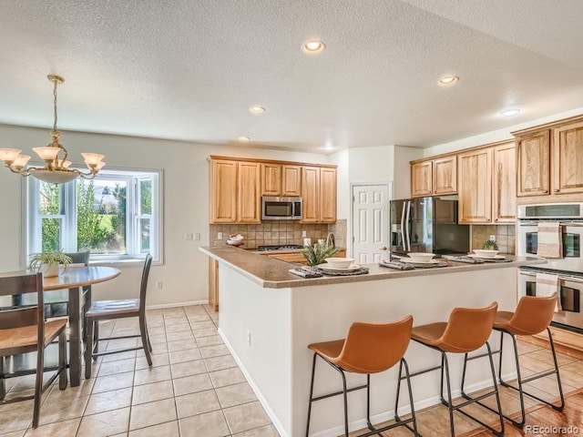 7746 S Valdai Ct, Aurora, CO 80016 - kitchen with stainless steel appliances, a chandelier, decorative backsplash, recessed lighting, and a kitchen bar