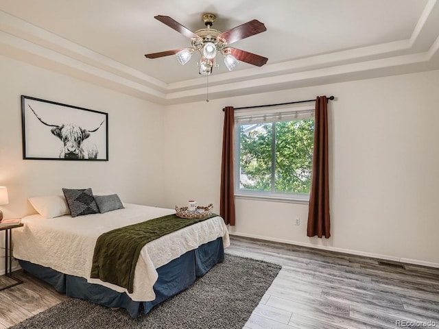 7746 S Valdai Ct, Aurora, CO 80016 - bedroom with a tray ceiling, wood finished floors, and ceiling fan