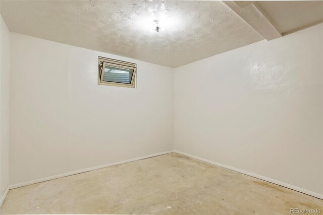 empty room featuring baseboards and unfinished concrete flooring